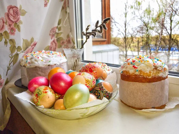 Paskalya bayramı. Pastalar ve renkli yumurtalar pencere eşiğinde. — Stok fotoğraf