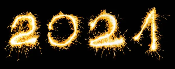Year 2021 number written in sparklers on a black background. New Year concept