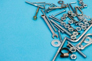 Mavi arka planda cıvatalar, fındıklar, anahtarlar ve diğer inşaat aletleri. Babalar günü konsepti. Kopyalama alanı