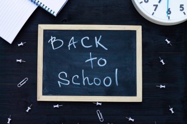 Siyah tahta tebeşir tahtası, beyaz malzeme ve saat. Üst Manzara. Uzayı kopyala Eğitim kavramı.