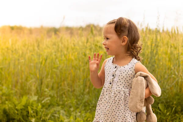 Klein Schattig Meisje Met Een Pluche Haas Een Lichte Jurk — Stockfoto