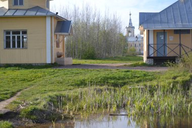 Eski ahşap evler ve tarlada bir kilise.