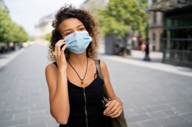 Maskeli kız sokakta bir telefon görüşmesi yaptı.