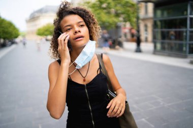 Maskeli kız sokakta bir telefon görüşmesi yaptı.