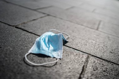 Ağzının önünde maske takan genç bir kadının portresi. 