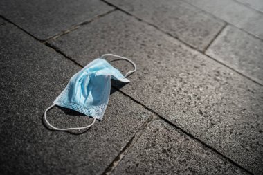 Kullanılmış maske yere atma, kirlilik konsepti