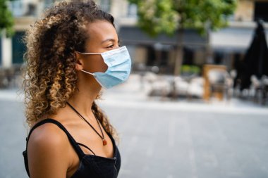 Coronavirus 'a karşı yüz maskesi takan bir kadın sokakta yürüyor.