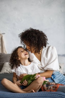 Mutlu kadınlar günü. Anne ve kızı Lale. Anne ve kız Afro-Amerikan görünüm parantez ile gülümseyen