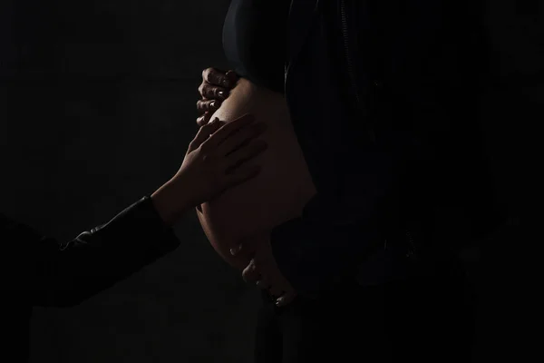 Close Up z kobieta w ciąży brzuch, widok z boku. sylwetka kobiety w ciąży na czarnym tle — Zdjęcie stockowe