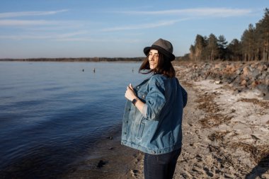 İnanılmaz derecede çekici genç kız dans ve müzik keyfi, kablosuz kulaklık ile Sahil yakınındaki yürüyor. Açık havada görüntüleri