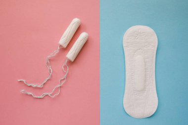 Pembe arka planda kadınsı sıhhi ped ve tampon. Konce