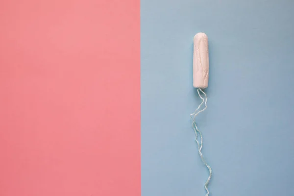 Жіночий гігієнічний тампон на рожевому тлі. Поняття жіночої гігієни під час менструацій. Плоский прошарок, вид зверху . — стокове фото