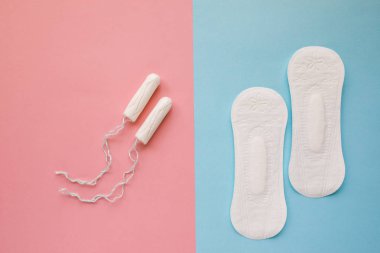 Pembe arka planda kadınsı sıhhi ped ve tampon. Konce