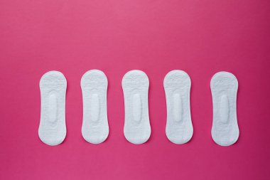 Kadın hijyen yastık pembe bir arka plan üzerinde. Menstruasyon sırasında kadın hijyen kavramını. Düz yatıyordu, en iyi görünümü.