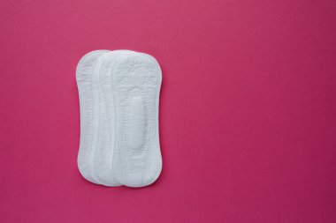 Kadın hijyen yastık pembe bir arka plan üzerinde. Menstruasyon sırasında kadın hijyen kavramını. Düz yatıyordu, en iyi görünümü.