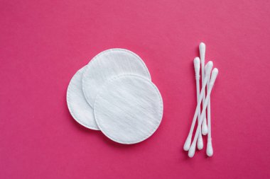 Pamuk temizleme bezi ve pembe bir arka plan üzerinde izole diskler. Hijyen ürünleri.