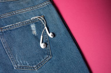 Kopya alanı ile düz arka plan. Rahat kadın kıyafeti, kot pantolon ve kulaklıkların üst görünümü