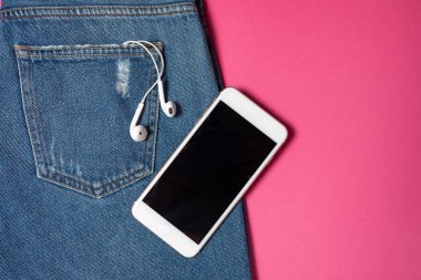 Kopya alanı ile düz arka plan. Rahat kadın kıyafeti, kot pantolon ve kulaklıkların üst görünümü