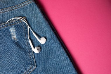 Kopya alanı ile düz arka plan. Rahat kadın kıyafeti, kot pantolon ve kulaklıkların üst görünümü