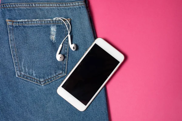 Kopya alanı ile düz arka plan. Rahat kadın kıyafeti, kot pantolon ve kulaklıkların üst görünümü