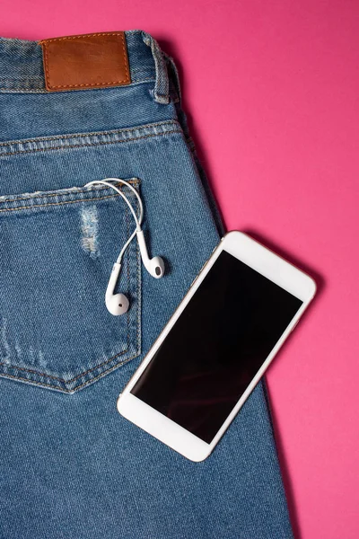 Kopya alanı ile düz arka plan. Rahat kadın kıyafeti, kot pantolon ve kulaklıkların üst görünümü