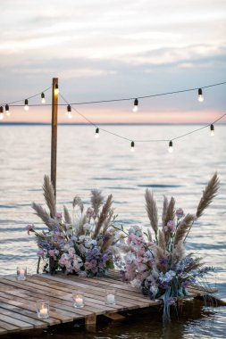 Sea wedding decor on the coast. Evening wedding ceremony near the water clipart