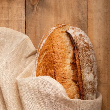 Peçetedeki tahta bir masada taze ekmek. Kopya sp ile üst görünüm