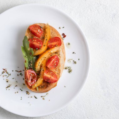 Beyaz arka plan karşı beyaz bir tabak üzerinde domates ile İtalyan bruschetta. Yukarıdan görüntüle
