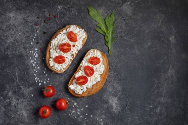 Bruschetta domates ve peynir yeşillik ile koyu bir arka plan üzerinde. Üst görünüm, kopyalama alanı.