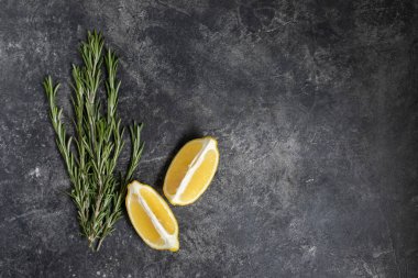 Koyu dokusal arka planda taze limon ve biberiye