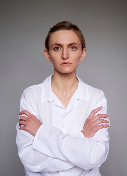 Gri arkaplan üzerinden kadın doktor ya da bilim adamı kapatın. Kollar göğüste çapraz