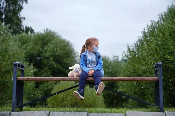 Niña Una Máscara Sienta Banco Con Juguete Una Máscara Fotos de stock