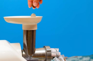 Para bir kıyma makinesi ile geçer. Mavi arka plan.