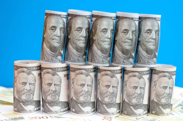 Mnoho zkroucené dolarové bankovky na modrém pozadí. — Stock fotografie