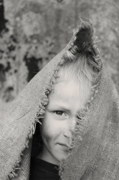 stock image The head portrait of a poor boy. Head in a sackcloth. Emotions.