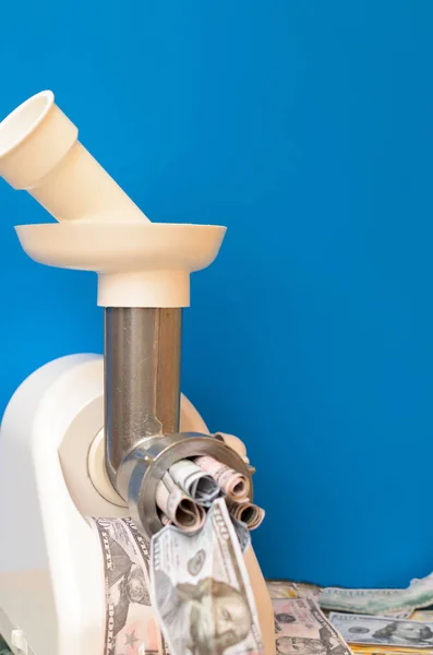 Para bir kıyma makinesi ile geçer. Mavi arka plan.