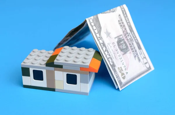 Toy house och pengar räkningar. Begreppet av lån till bostäder. — Stockfoto