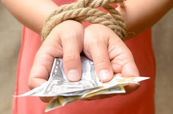 Kadınların elleri bir ip ve holding para ile bağlı. Kredi esaret.