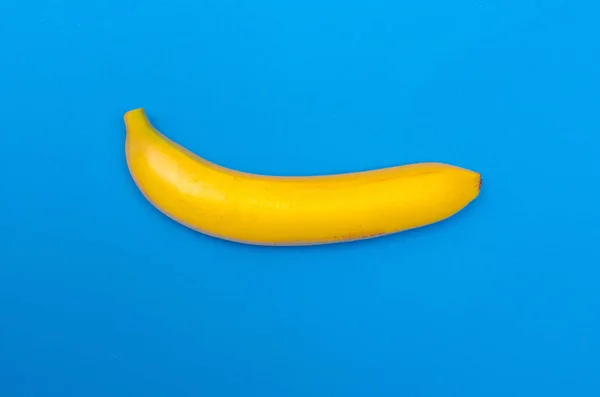 Banana matura su sfondo blu. Il concetto di alimentazione sana. Il concetto di estate . — Foto Stock