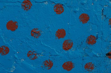 Bordo yamalar ile mavi boya ile boyanmış duvar bölümü.