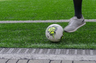 Ayak futbolcu saha kenarından topa vurur.