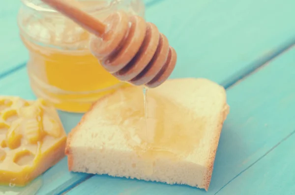 Accesorios de miel y miel para su uso sobre un fondo de madera azul . — Foto de Stock