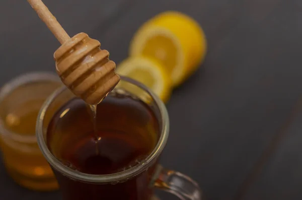 Bir fincan çay, dilimlenmiş limon ve bir kavanoz bal bileşimi. — Stok fotoğraf