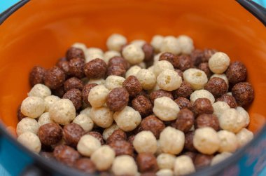 Mavi ahşap arka plan üzerinde kahvaltılık gevrek ile Mısır bardak.