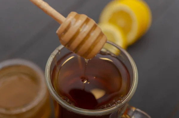 Bir fincan çay, dilimlenmiş limon ve bir kavanoz bal bileşimi. — Stok fotoğraf