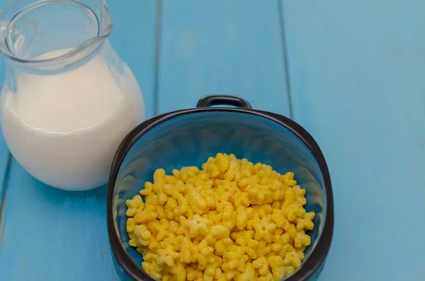 Copas de maíz con cereales de desayuno sobre fondo de madera azul . — Foto de Stock