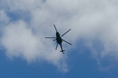 Gökyüzünde uçan bir helikopter silueti.