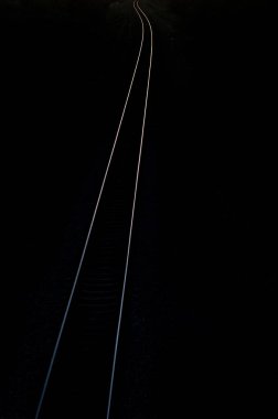 Karanlıkta raylar dar bir yol bırakıyor..