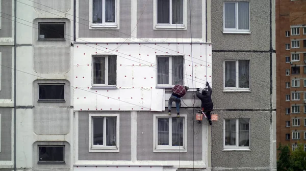 climbers work on the building, climbers are working on the insulation of facades of a multi-storey residential building