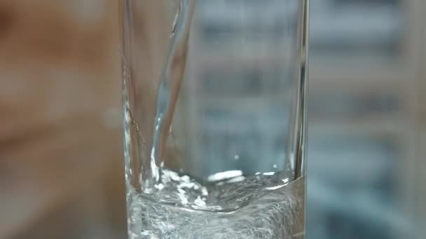 minerální voda se nalije do sklenice z láhve zblízka, pohyblivý fotoaparát